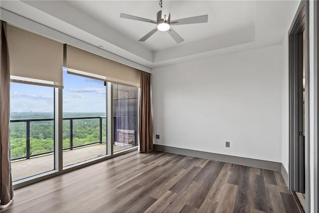 3630 Peachtree Rd NE Unit 2207, Atlanta, GA 30326 - unfurnished room featuring wood finished floors, a tray ceiling, a ceiling fan, and baseboards