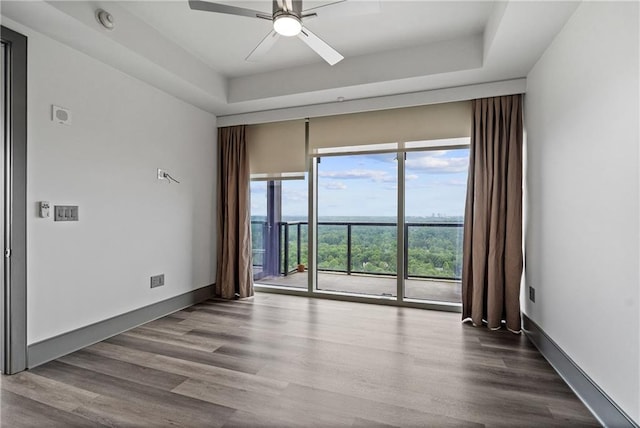 3630 Peachtree Rd NE Unit 2207, Atlanta, GA 30326 - empty room featuring a ceiling fan, wood finished floors, a tray ceiling, and baseboards
