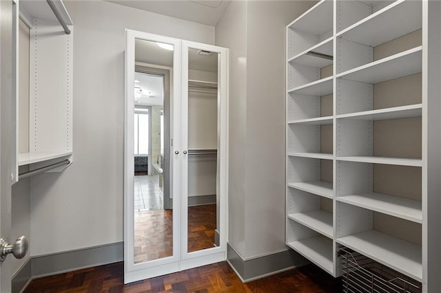 spacious closet with dark parquet floors