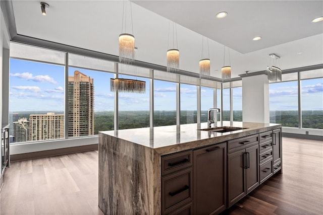 3630 Peachtree Rd NE Unit 2207, Atlanta, GA 30326 - kitchen featuring a sink, wood finished floors, light stone counters, decorative light fixtures, and recessed lighting