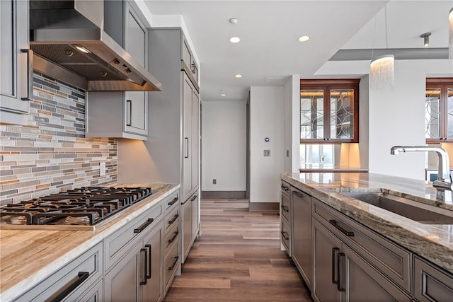3630 Peachtree Rd NE Unit 2207, Atlanta, GA 30326 - kitchen featuring a sink, stainless steel gas stovetop, wall chimney range hood, recessed lighting, and light stone counters