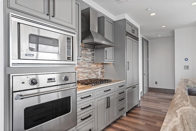 3630 Peachtree Rd NE Unit 2207, Atlanta, GA 30326 - kitchen with stainless steel appliances, wall chimney exhaust hood, gray cabinets, dark wood-type flooring, and backsplash
