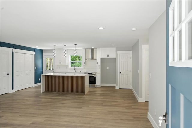 376 Wayside Ln, Dallas, GA 30132 - kitchen featuring stainless steel electric range, wall chimney exhaust hood, white cabinetry, a kitchen island, and light countertops