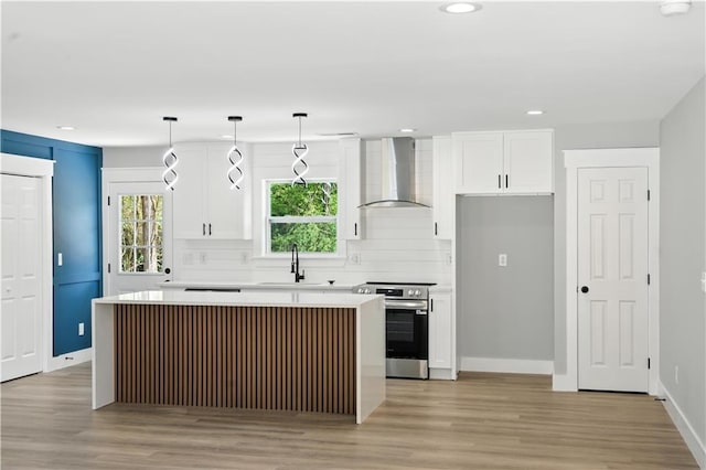 376 Wayside Ln, Dallas, GA 30132 - kitchen with stainless steel range with electric cooktop, wall chimney range hood, a center island, white cabinetry, and recessed lighting