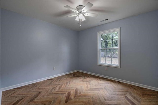 unfurnished room with ceiling fan and parquet flooring