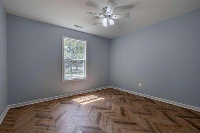 spare room featuring ceiling fan and dark parquet flooring