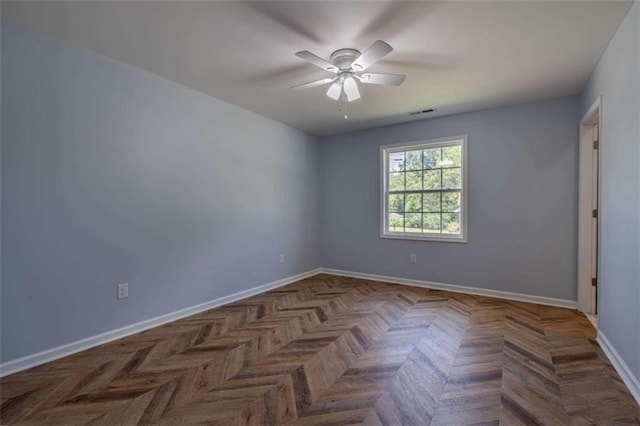 empty room featuring ceiling fan and dark parquet flooring