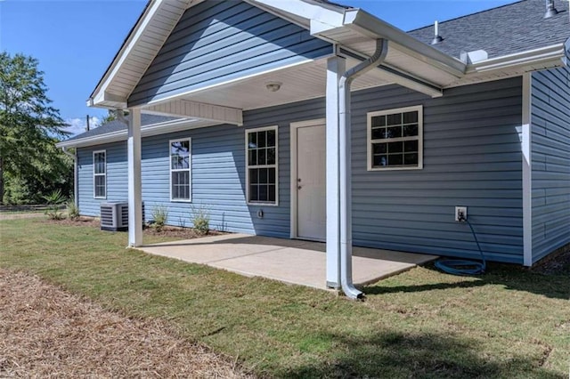 back of property featuring a patio, a yard, and central AC