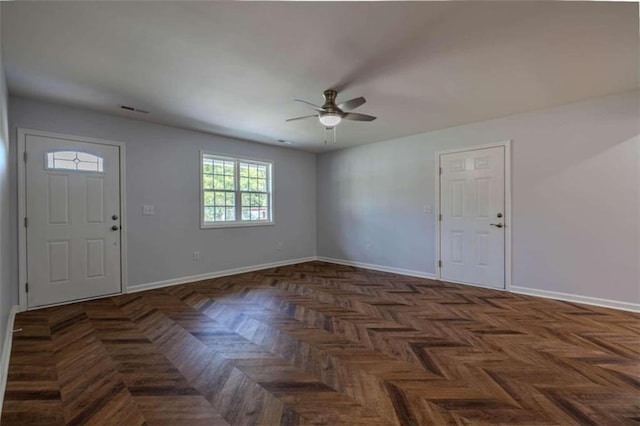 foyer with ceiling fan and dark parquet flooring