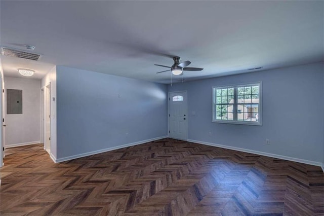 unfurnished room with ceiling fan, electric panel, and dark parquet flooring