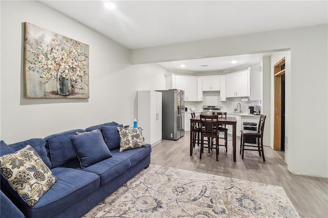 living room with sink and light hardwood / wood-style flooring