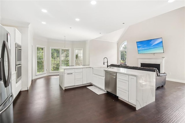 kitchen featuring pendant lighting, appliances with stainless steel finishes, sink, and white cabinets