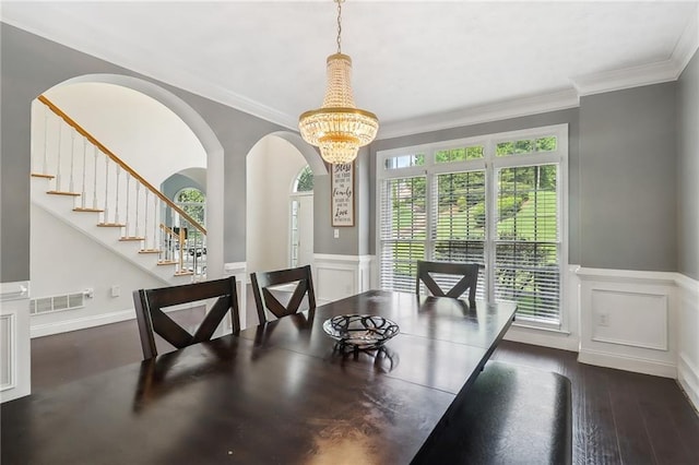 dining area with ornamental molding, dark hardwood / wood-style floors, and a notable chandelier