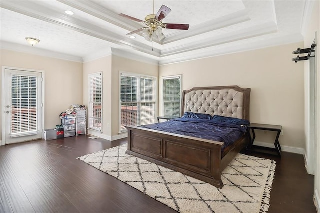 bedroom featuring crown molding, access to outside, a tray ceiling, dark hardwood / wood-style flooring, and ceiling fan