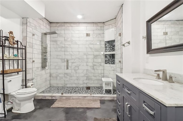 bathroom with vanity, a shower with shower door, concrete floors, and toilet