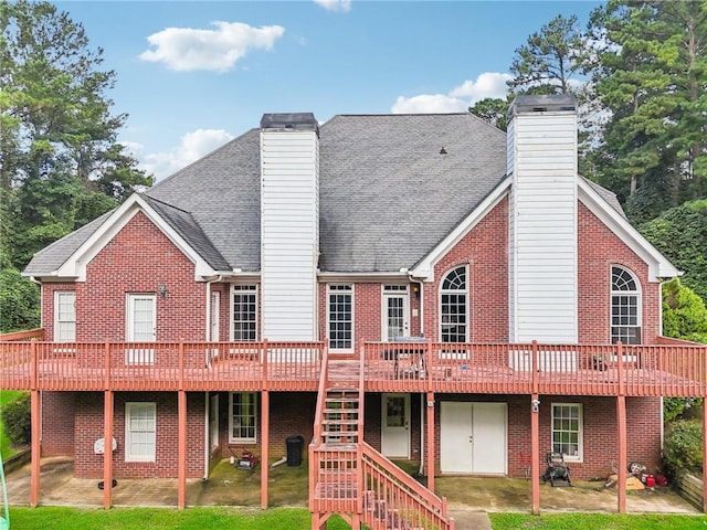 back of property featuring a wooden deck and a lawn