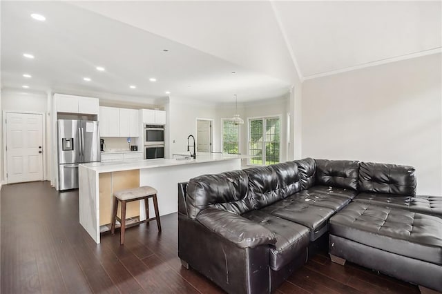 living room with dark hardwood / wood-style flooring, sink, and ornamental molding