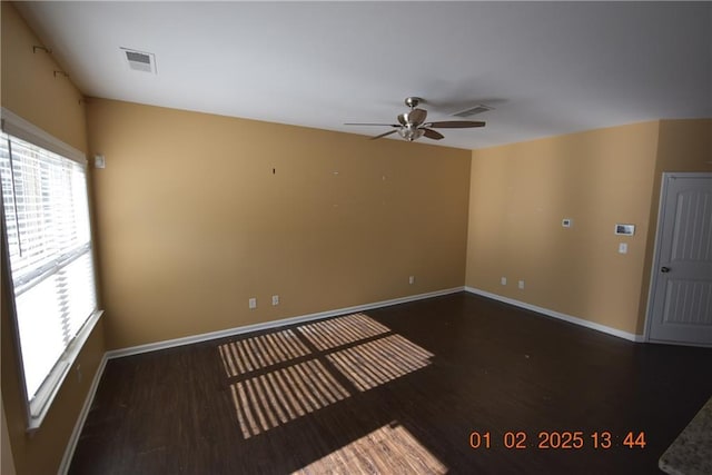 empty room with ceiling fan and dark hardwood / wood-style flooring