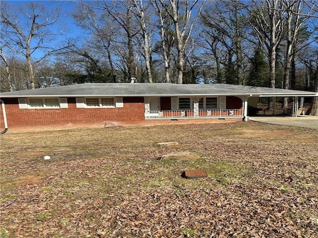 single story home with covered porch, an attached carport, concrete driveway, and brick siding