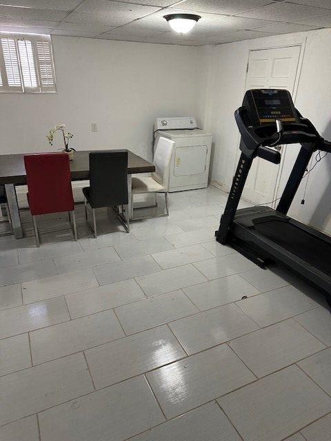 exercise area featuring a drop ceiling and washer / dryer