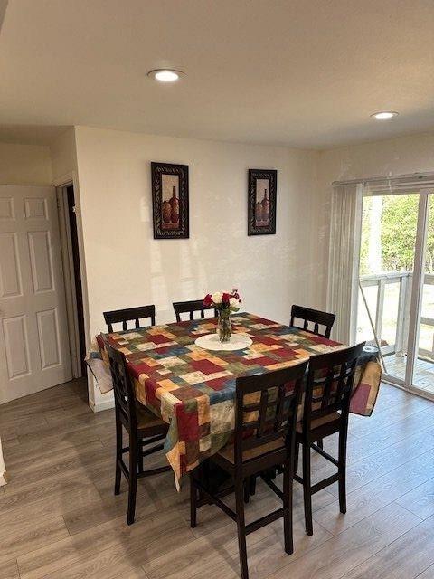 dining space with wood finished floors and recessed lighting
