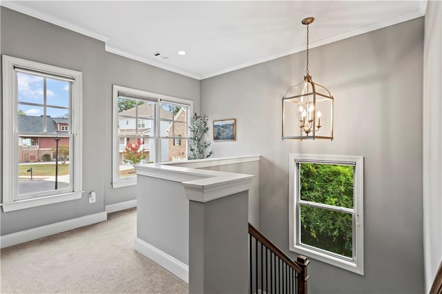 hall featuring a notable chandelier, light colored carpet, and ornamental molding