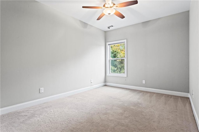 carpeted spare room with ceiling fan