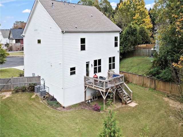 back of property featuring a lawn, a wooden deck, and central AC