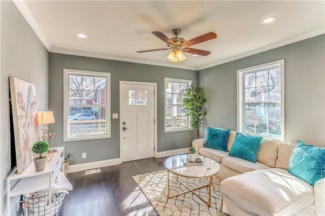 living area with dark wood-style floors, visible vents, baseboards, ceiling fan, and ornamental molding