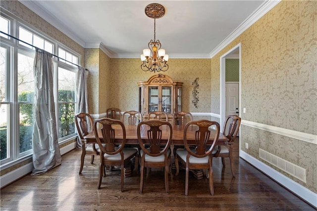 dining space with wallpapered walls, visible vents, wood finished floors, crown molding, and a notable chandelier