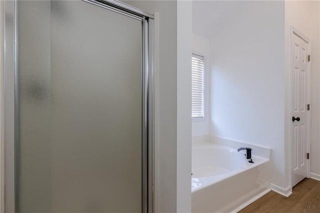 bathroom featuring separate shower and tub and hardwood / wood-style floors