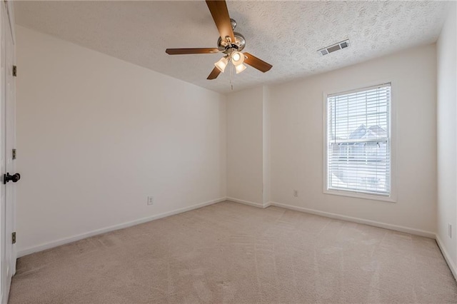 carpeted empty room featuring ceiling fan and a textured ceiling