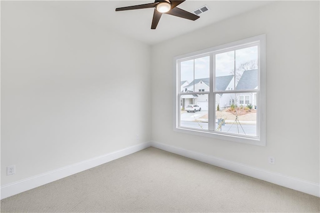 spare room featuring plenty of natural light, carpet, and visible vents