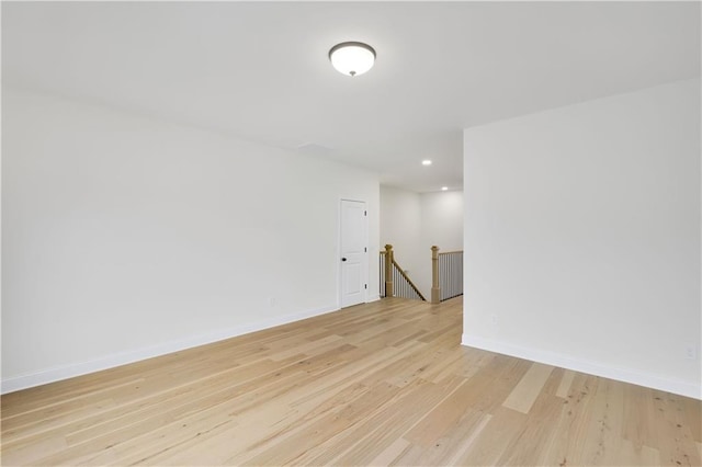 spare room with light wood-type flooring, baseboards, and recessed lighting