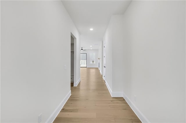 corridor featuring recessed lighting, light wood-type flooring, and baseboards