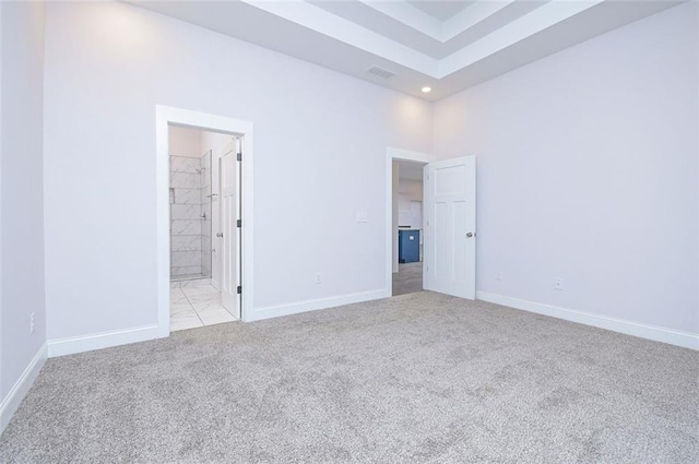 unfurnished bedroom featuring light colored carpet and ensuite bath