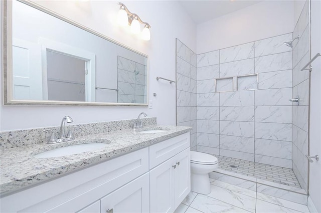 bathroom featuring vanity, toilet, and tiled shower