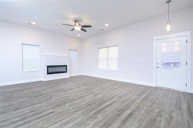 unfurnished living room with ceiling fan and dark hardwood / wood-style floors