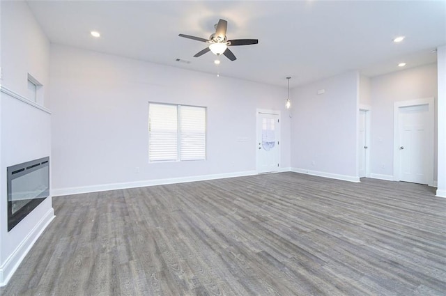 unfurnished living room with dark hardwood / wood-style floors and ceiling fan