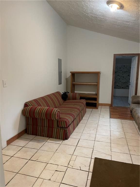 304 E 19th St SW, Rome, GA 30161 - living area with lofted ceiling, a textured ceiling, light tile patterned floors, electric panel, and baseboards