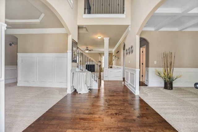 foyer featuring beam ceiling, dark wood-type flooring, ornamental molding, and ceiling fan