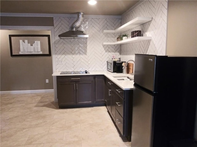 kitchen with stainless steel refrigerator, black electric cooktop, sink, and decorative backsplash