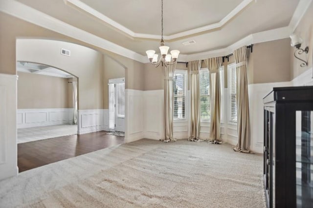 unfurnished room featuring a raised ceiling and an inviting chandelier