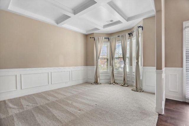 carpeted empty room featuring coffered ceiling and beam ceiling