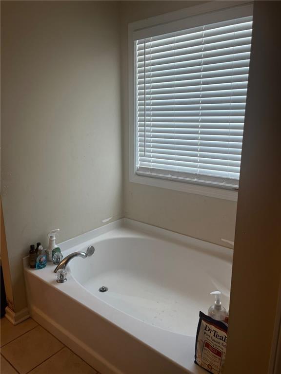 bathroom with tile patterned floors and a bathtub