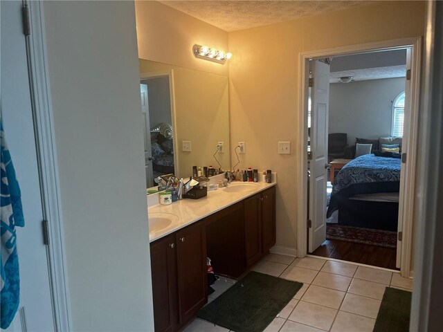 bathroom featuring vanity, ceiling fan, a textured ceiling, and tile patterned floors