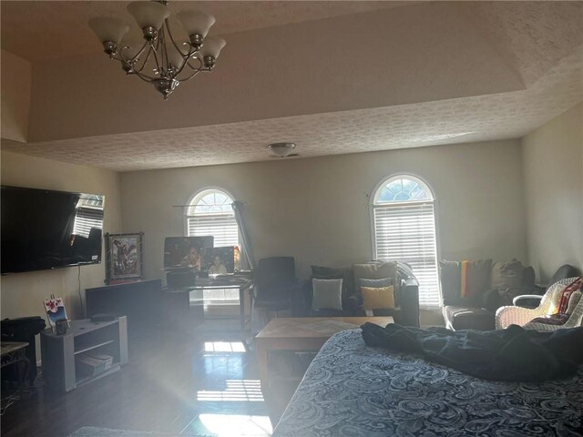 bedroom with a textured ceiling, multiple windows, and an inviting chandelier