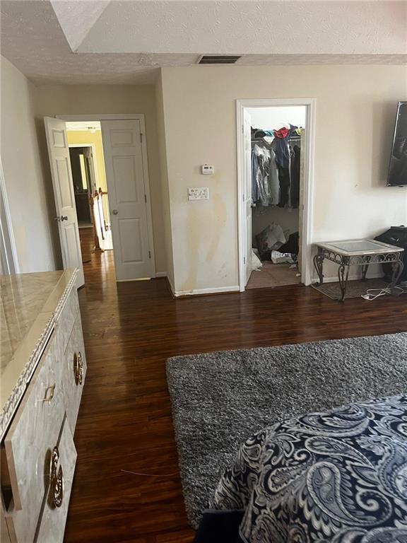 hall with a textured ceiling and dark hardwood / wood-style flooring