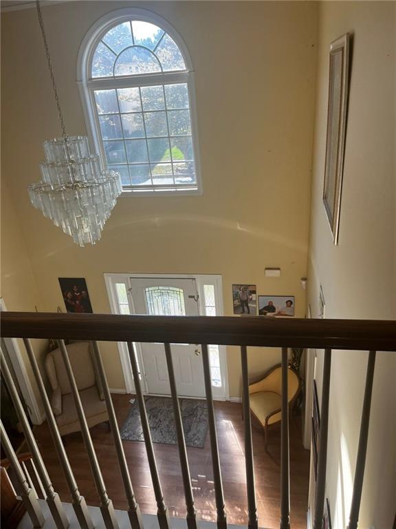 stairway with a notable chandelier and wood-type flooring