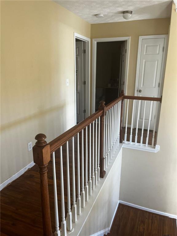 staircase featuring wood-type flooring and a textured ceiling